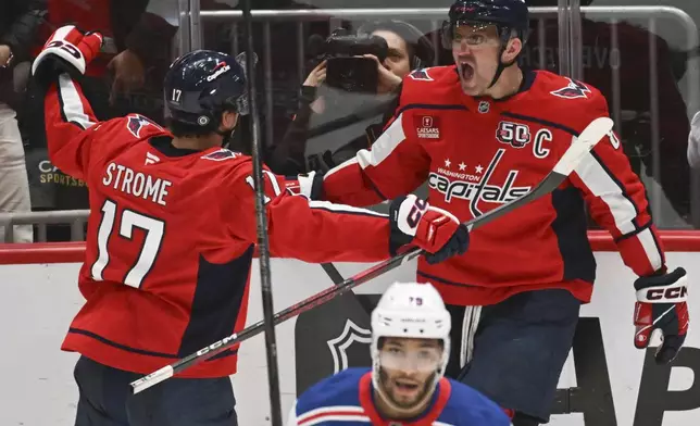 Washington Capitals center Dylan Strome (17) celebrates with left wing Alex Ovechkin after scoring a goal in the third period goal of an NHL hockey game against the New York Rangers, Saturday, Jan. 4, 2025, in Washington. (AP Photo/John McDonnell)