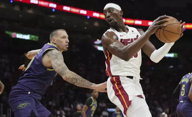 New Orleans Pelicans center Daniel Theis, left, defends Miami Heat center Bam Adebayo, right, during the first half of an NBA basketball game, Wednesday, Jan. 1, 2025, in Miami. (AP Photo/Lynne Sladky)