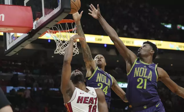 Miami Heat guard Alec Burks (18) goes to the basket as New Orleans Pelicans guard Jordan Hawkins (24) and center Yves Missi (21) defend during the first half of an NBA basketball game, Wednesday, Jan. 1, 2025, in Miami. (AP Photo/Lynne Sladky)