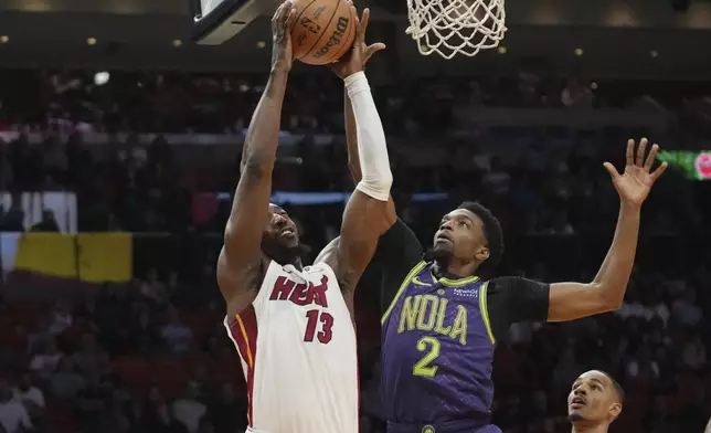 Miami Heat center Bam Adebayo (13) shoots as New Orleans Pelicans forward Herbert Jones (2) defends during the first half of an NBA basketball game, Wednesday, Jan. 1, 2025, in Miami. (AP Photo/Lynne Sladky)