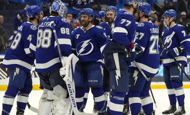 Tampa Bay Lightning goaltender Andrei Vasilevskiy (88) celebrates with teammates after the team defeated the Carolina Hurricanes in an NHL hockey game Tuesday, Jan. 7, 2025, in Tampa, Fla. (AP Photo/Chris O'Meara)