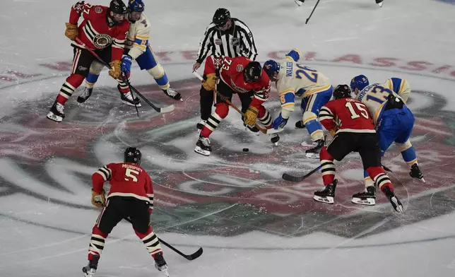 The Chicago Blackhawks and St. Louis Blues face off at center ice during the NHL Winter Classic outdoor hockey game at Wrigley Field, Tuesday, Dec. 31, 2024, in Chicago. (AP Photo/Erin Hooley)