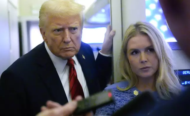 FILE - President Donald Trump speaks to reporters aboard Air Force One en route from Miami to Joint Base Andrews, Md., Jan. 27, 2025, as White House press secretary Karoline Leavitt listens. (AP Photo/Mark Schiefelbein, File)
