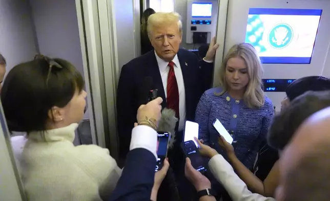 FILE - President Donald Trump speaks to reporters aboard Air Force One en route from Miami to Joint Base Andrews, Md., Jan. 27, 2025, as White House press secretary Karoline Leavitt listens. (AP Photo/Mark Schiefelbein, File)