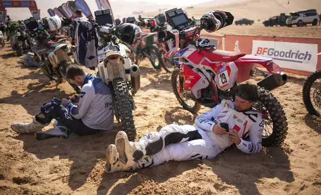 Riders wait at the start delayed due to fog during the eleventh stage of the Dakar Rally with start and finish in Shubaytah, Saudi Arabia, Thursday, Jan. 16, 2025. (AP Photo/Christophe Ena)
