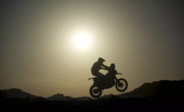 A rider jumps during the sixth stage of the Dakar Rally between Hail and Al Duwadimi, Saudi Arabia, Saturday, Jan. 11, 2025. (AP Photo/Christophe Ena)