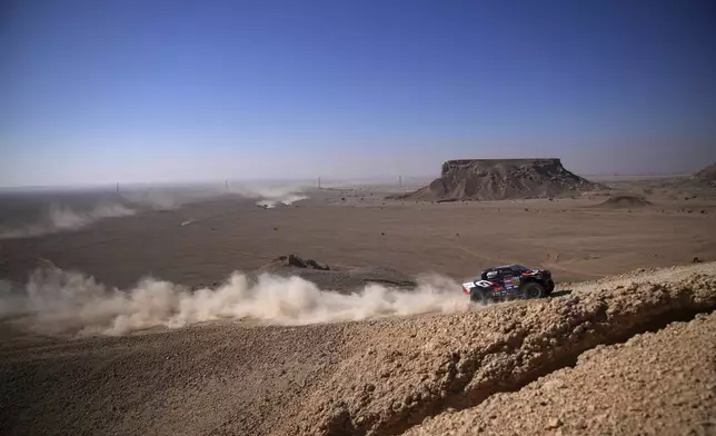 Driver Henk Lategan and co-driver Brett Cummings compete during the ninth stage of the Dakar Rally between Riyadh and Haradh, Saudi Arabia, Tuesday, Jan. 14, 2025. (AP Photo/Christophe Ena)
