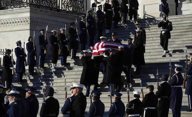 A joint services body bearer team carries the flag-draped casket of former President Jimmy Carter from the U.S. Capitol in Washington, Thursday, Jan. 9, 2025, to head to Washington National Cathedral for a State Funeral. (AP Photo/Susan Walsh, Pool)