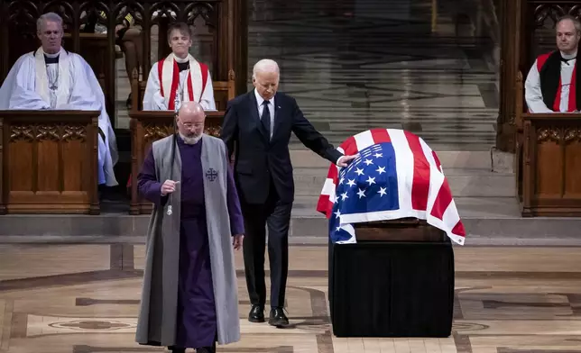 President Joe Biden touches the casket of former President Jimmy Carter after delivering remarks during Carter's state funeral at the National Cathedral, Thursday, Jan. 9, 2025, in Washington. (Haiyun Jiang/The New York Times via AP, Pool)