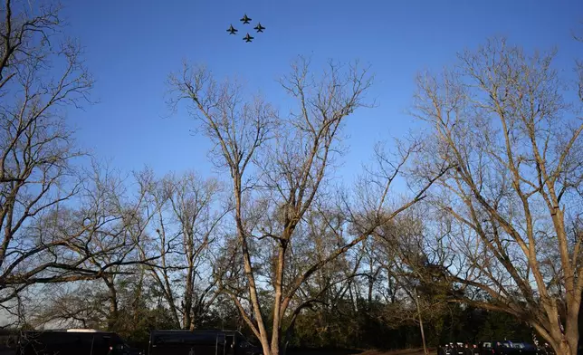 U.S. Navy F/A-18 Super Hornets perform a fly-over as as the casket of former President Jimmy Carter, bottom right, arrives at Maranatha Baptist Church for a funeral service, Thursday, Jan. 9, 2025, in Plains, Ga. (AP Photo/Mike Stewart)