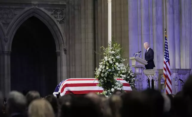 President Joe Biden speaks a tribute next to the flag-draped casket of former President Jimmy Carter, during a state funeral at Washington National Cathedral, Thursday, Jan. 9, 2025, in Washington. (AP Photo/Ben Curtis)