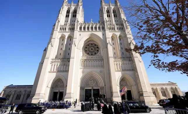 A joint services body bearer team carries the flag-draped casket of former President Jimmy Carter out of Washington National Cathedral, Thursday, Jan. 9, 2025, following a State Funeral. (AP Photo/Mark Schiefelbein)