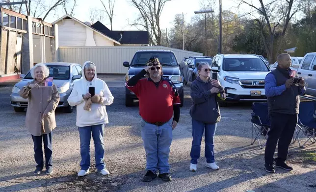 People watch as the hearse containing the flag-draped casket of former President Jimmy Carter passes in the motorcade in Richland, Ga., from Lawson Army Airfield, in Fort Moore, Ga., to Maranatha Baptist Church in Plains, Ga., Thursday, Jan. 9, 2025. (AP Photo/Alex Brandon, Pool)