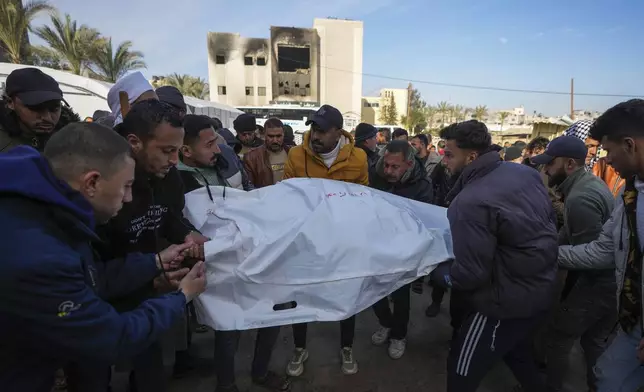 Palestinians carry white sacks containing the bodies of those killed in overnight Israeli airstrikes on the Khan Younis refugee camp, southern Gaza Strip, Saturday, Jan. 4, 2025. (AP Photo/Abdel Kareem Hana)