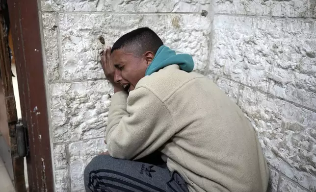 A man mourns the death of his relatives at Al-Aqsa Martyrs Hospital following Israeli army airstrikes in Deir al-Balah, central Gaza Strip, Saturday, Jan. 4, 2025. (AP Photo/Abdel Kareem Hana)