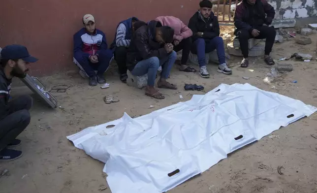 Relatives of a Palestinian killed in overnight Israeli strikes, mourn over his body outside the morgue of Nasser hospital in the Khan Younis refugee camp, southern Gaza Strip, Saturday, Jan. 4, 2025. (AP Photo/Abdel Kareem Hana)