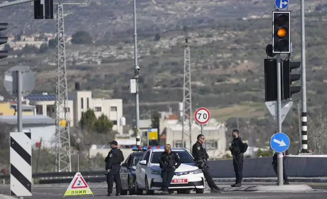 Israeli policemen block a main road after gunmen opened fire on cars and a bus carrying Israelis in the occupied West Bank, killing at least three people, near the Palestinian village of Al-Funduq, Monday, Jan. 6, 2025. (AP Photo/Nasser Nasser)