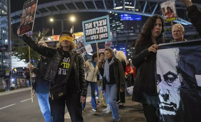 Israelis protest against Prime Minister Benjamin Netanyahu's government and call for the release of hostages, held in the Gaza Strip by the Hamas militant group, in Tel Aviv, Israel, Monday, Jan. 6, 2025. (AP Photo/Ohad Zwigenberg)