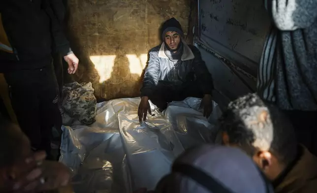 Mourners attend the funeral of three members of Imad Al-deen family who were killed in the Israeli bombardment in Bureij, central Gaza Strip, at Al-Aqsa Martyrs Hospital in Deir al-Balah, Monday, Jan. 6, 2025. (AP Photo/Abdel Kareem Hana)