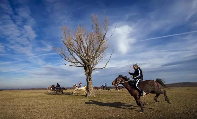 Men ride horses while competing in a traditional race during Epiphany celebrations in the village of Pietrosani, Romania, Monday, Jan. 6, 2025. (AP Photo/Vadim Ghirda)