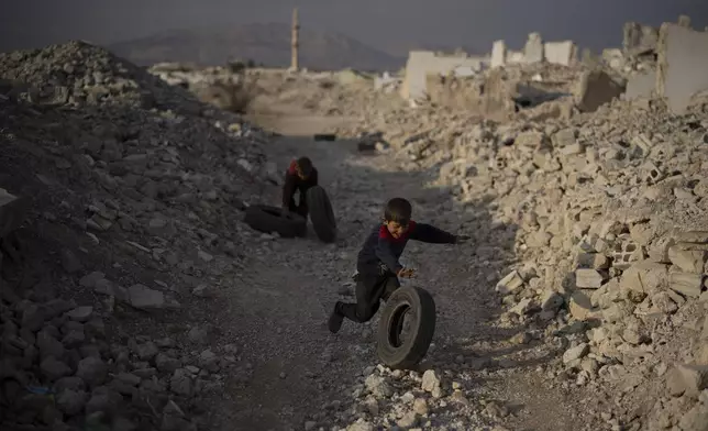 Kids play surrounded by rubble on a an area of houses that were completely destroyed during the civil war at the Al-Asali neighbourhood in Damascus, Syria, Monday, Jan. 6, 2025. (AP Photo/Leo Correa)