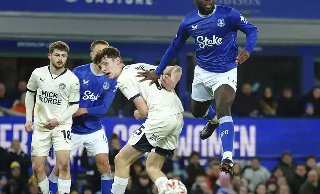 Everton's Orel Mangala, right, and Peterborough United's George Nevett in action during the English FA Cup third round soccer match between Everton and Peterborough United at Goodison Park, Liverpool, England, Thursday Jan. 9, 2025. (Peter Byrne/PA via AP)