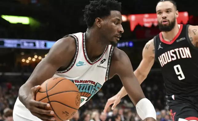 Memphis Grizzlies forward Jaren Jackson Jr., left, handles the ball against Houston Rockets forward Dillon Brooks (9) in the second half of an NBA basketball game Thursday, Jan. 30, 2025, in Memphis, Tenn. (AP Photo/Brandon Dill)