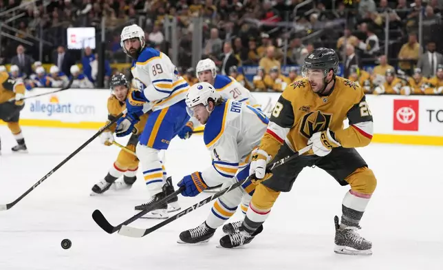 Buffalo Sabres defenseman Bowen Byram (4) skates for the puck against Vegas Golden Knights center Tanner Laczynski (28) during the second period of an NHL hockey game, Saturday, Jan. 4, 2025, in Las Vegas. (AP Photo/Lucas Peltier)