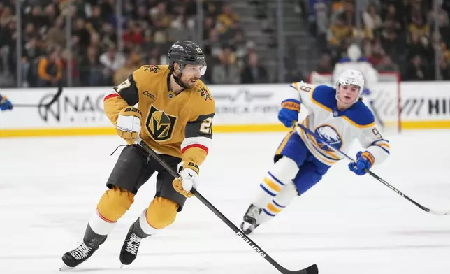 Vegas Golden Knights defenseman Shea Theodore (27) skates with the puck against Buffalo Sabres left wing Zach Benson (9) during the first period of an NHL hockey game, Saturday, Jan. 4, 2025, in Las Vegas. (AP Photo/Lucas Peltier)