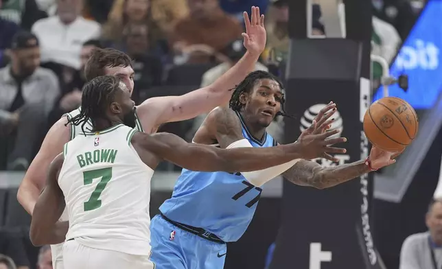 Los Angeles Clippers guard Kevin Porter Jr., right, tries to pass while under pressure from Boston Celtics forward Baylor Scheierman, left, and guard Jaylen Brown during the first half of an NBA basketball game, Wednesday, Jan. 22, 2025, in Inglewood, Calif. (AP Photo/Mark J. Terrill)