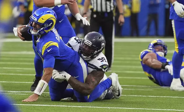 Los Angeles Rams quarterback Jimmy Garoppolo (11) is sacked by Seattle Seahawks defensive end Leonard Williams (99) during the second half of an NFL football game Sunday, Jan. 5, 2025, in Inglewood, Calif. (AP Photo/Mark J. Terrill)