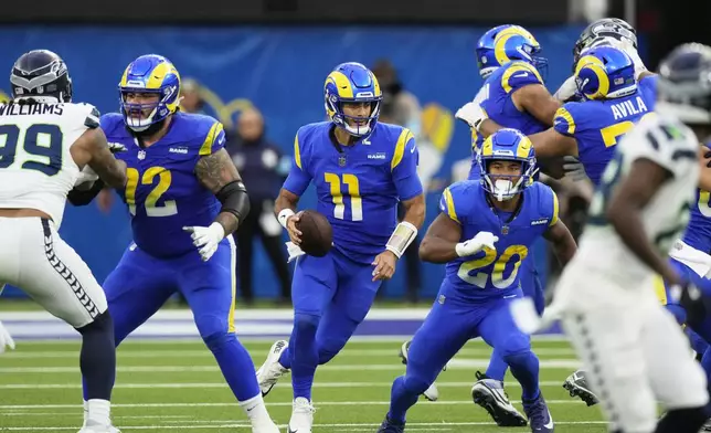 Los Angeles Rams quarterback Jimmy Garoppolo (11) runs through blockers during the second half of an NFL football game against the Seattle Seahawks, Sunday, Jan. 5, 2025, in Inglewood, Calif. (AP Photo/Mark J. Terrill)