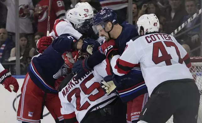 New Jersey Devils' Paul Cotter (47) pulls New York Rangers' Sam Carrick (39) away from Jacob Markstrom (25) during the third period of an NHL hockey game, Thursday, Jan. 9, 2025, in New York. (AP Photo/Frank Franklin II)