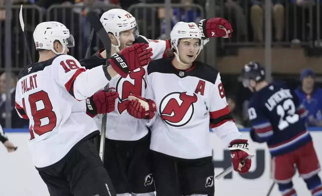 New Jersey Devils' Jack Hughes (86) celebrates with teammates Ondrej Palat (18) and Brett Pesce (22) after scoring a goal during the second period of an NHL hockey game against the New York Rangers, Thursday, Jan. 9, 2025, in New York. (AP Photo/Frank Franklin II)