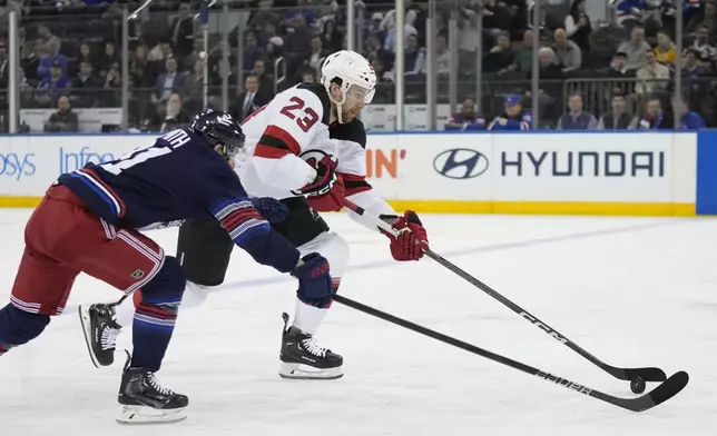 New Jersey Devils' Kurtis MacDermid (23) drives past New York Rangers' Reilly Smith (91) during the second period of an NHL hockey game, Thursday, Jan. 9, 2025, in New York. (AP Photo/Frank Franklin II)