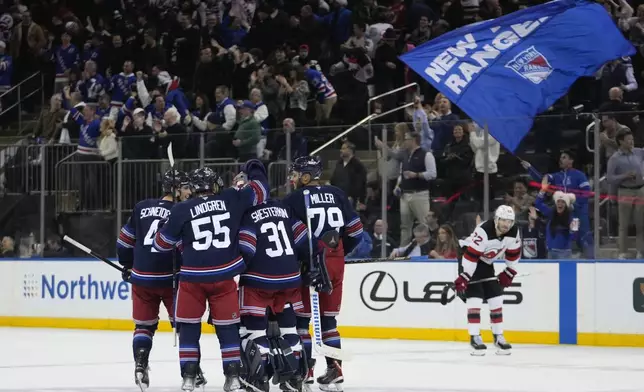 New York Rangers goaltender Igor Shesterkin (31) celebrates with teammates Ryan Lindgren (55), K'Andre Miller (79) and Braden Schneider (4) as New Jersey Devils' Brett Pesce (22) leaves the ice after an NHL hockey game, Thursday, Jan. 9, 2025, in New York. (AP Photo/Frank Franklin II)