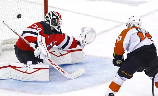 Philadelphia Flyers right wing Bobby Brink (10) scores a goal past New Jersey Devils goaltender Jake Allen (34) during the third period of an NHL hockey game, Saturday, Jan. 18, 2025, in Newark, N.J. (AP Photo/Noah K. Murray)