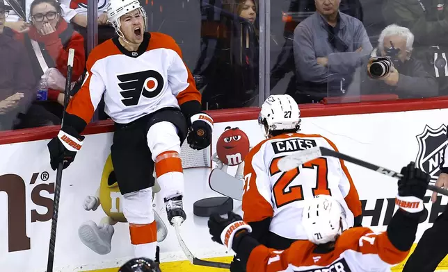 Philadelphia Flyers right wing Bobby Brink (10) celebrates with Noah Cates (27) and Tyson Foerster (71) after scoring a goal against the New Jersey Devils during the third period of an NHL hockey game, Saturday, Jan. 18, 2025, in Newark, N.J. (AP Photo/Noah K. Murray)