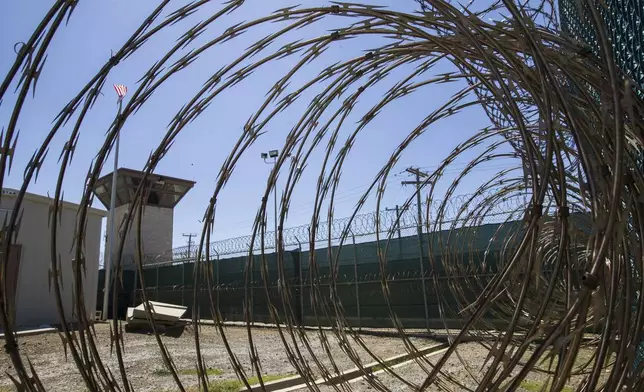 FILE - In this April 17, 2019, photo, reviewed by U.S. military officials, the control tower is seen through the razor wire inside the Camp VI detention facility in Guantanamo Bay Naval Base, Cuba. (AP Photo/Alex Brandon, File)