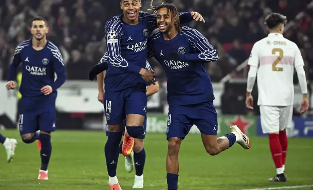 PSG's Bradley Barcola, centre right, celebrates with Desire Doue after scoring the opening goal during the Champions League opening phase soccer match between VfB Stuttgart and Paris Saint-Germain in Stuttgart, Germany, Jan. 29, 2025. (Marijan Murat/dpa via AP)