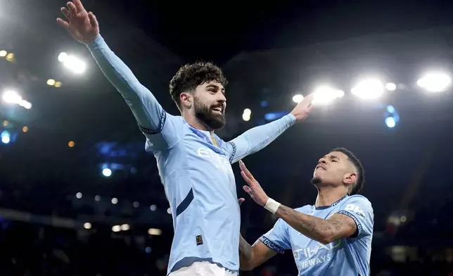 Manchester City's Josko Gvardiol, left, celebrates after his cross led to an own goal during the Champions League opening phase soccer match between Manchester City and Club Brugge at the Etihad Stadium in Manchester, Wednesday, Jan. 29, 2025. (Mike Egerton/PA via AP)