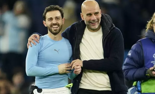 Manchester City's head coach Pep Guardiola celebrates with Bernardo Silva afte the Champions League opening phase soccer match between Manchester City and Club Brugge at the Etihad Stadium in Manchester, Wednesday, Jan. 29, 2025. (AP Photo/Dave Thompson)