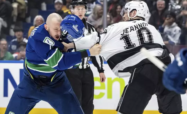 Vancouver Canucks' Vincent Desharnais, left, and Los Angeles Kings' Tanner Jeannot (10) fight during the first period of an NHL hockey game in Vancouver, British Columbia, Thursday, Jan. 16, 2025. (Ethan Cairns/The Canadian Press via AP)