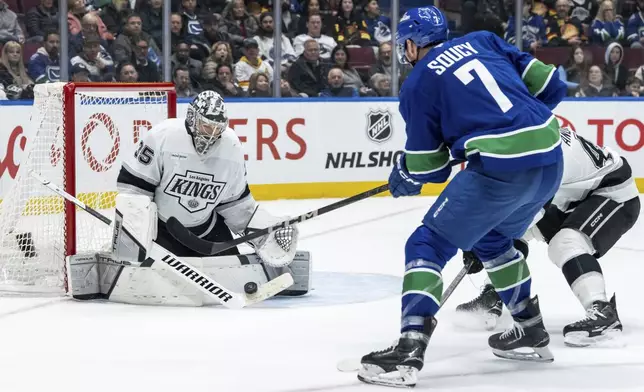 Los Angeles Kings goaltender Darcy Kuemper (35) stops the puck from Vancouver Canucks' Carson Soucy (7) during the third period of an NHL hockey game in Vancouver, British Columbia, Thursday, Jan. 16, 2025. (Ethan Cairns/The Canadian Press via AP)