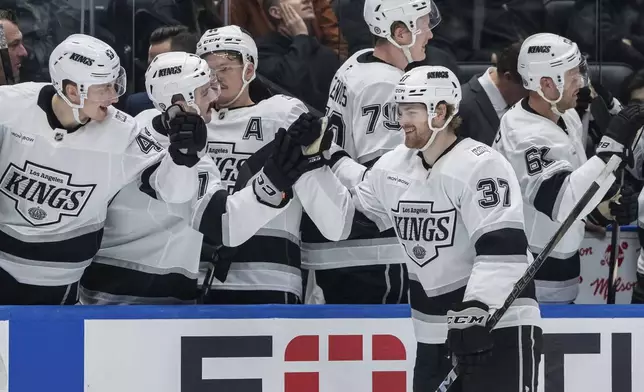 Los Angeles Kings' Warren Foegele (37) celebrates his goal against the Vancouver Canucks with teammates during the third period of an NHL hockey game in Vancouver, British Columbia, Thursday, Jan. 16, 2025. (Ethan Cairns/The Canadian Press via AP)