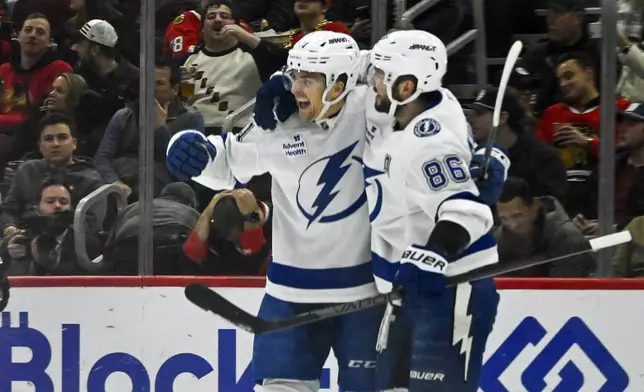 Tampa Bay Lightning right wing Mitchell Chaffee, left, celebrates his goal against the Chicago Blackhawks with right wing Nikita Kucherov (86), during the first period of an NHL hockey game, Friday, Jan. 24, 2025, in Chicago. (AP Photo/Matt Marton)