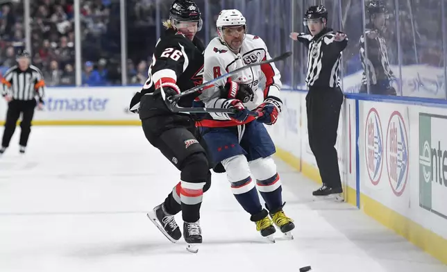 Buffalo Sabres defenseman Rasmus Dahlin, left, tries to shield Washington Capitals left wing Alex Ovechkin off the puck during the first period of an NHL hockey game in Buffalo, N.Y., Monday, Jan. 6, 2025. (AP Photo/Adrian Kraus)