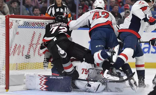 Washington Capitals defenseman Martin Fehervary (42) pushes Buffalo Sabres center Tage Thompson (72) over Capitals goalie Charlie Lindgren (79) during the second period of an NHL hockey game in Buffalo, N.Y., Monday, Jan. 6, 2025. (AP Photo/Adrian Kraus)