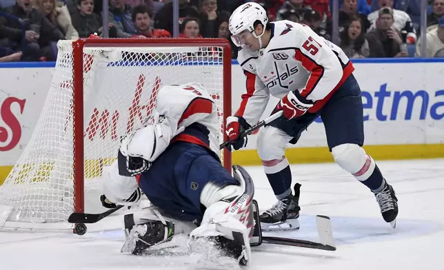 Washington Capitals defenseman Trevor van Riemsdyk, right, clears the puck off the line from behind goalie Charlie Lindgren during the second period of an NHL hockey game against the Buffalo Sabres in Buffalo, N.Y., Monday, Jan. 6, 2025. (AP Photo/Adrian Kraus)