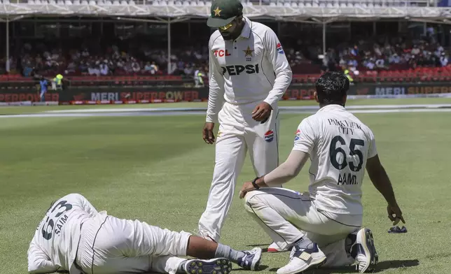 Pakistan's Saim Ayub, left, sits injured on the ground during the second test match between South Africa and Pakistan in Cape Town, South Africa, Friday, Jan. 3, 2025. (AP Photo/Halden Krog)